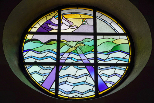 Glasfenster mit Motiv der Friedenstabue in der Friedenskirche Bad Wiessee